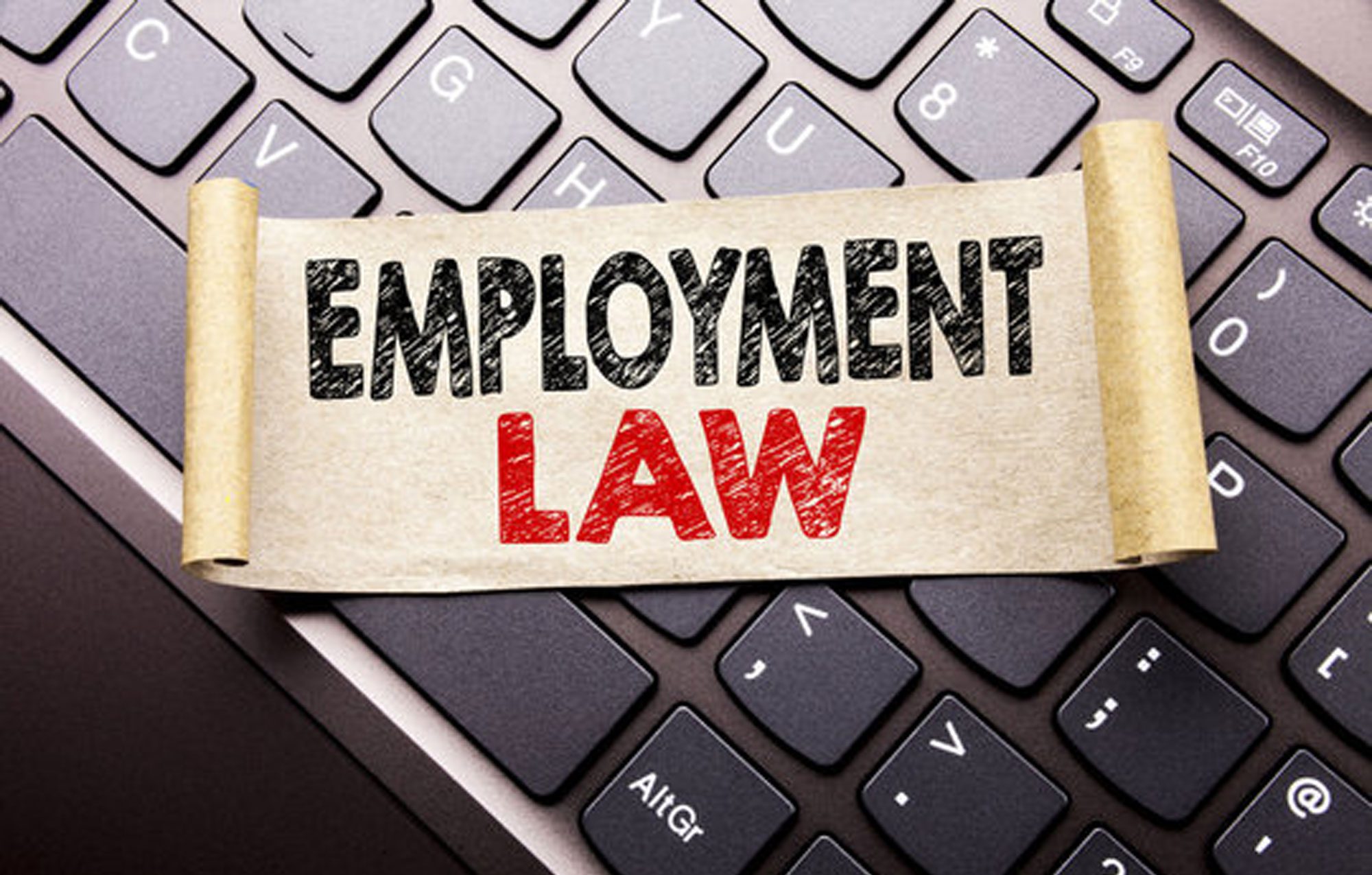 Employment law scroll resting on a computer keyboard, representing the legal services provided by Simantob Law Group.